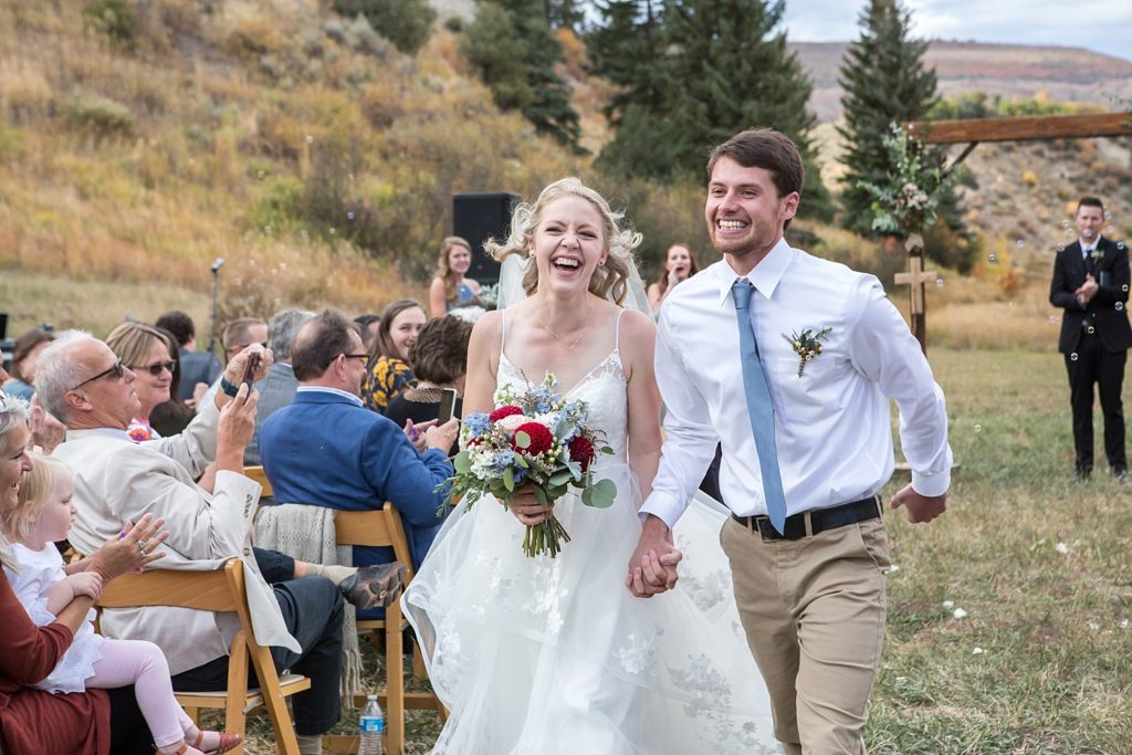 walking down the aisle after their Colorado mountain wedding
