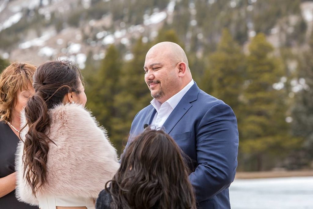 groom listening to vows at winter elopement in Colorado