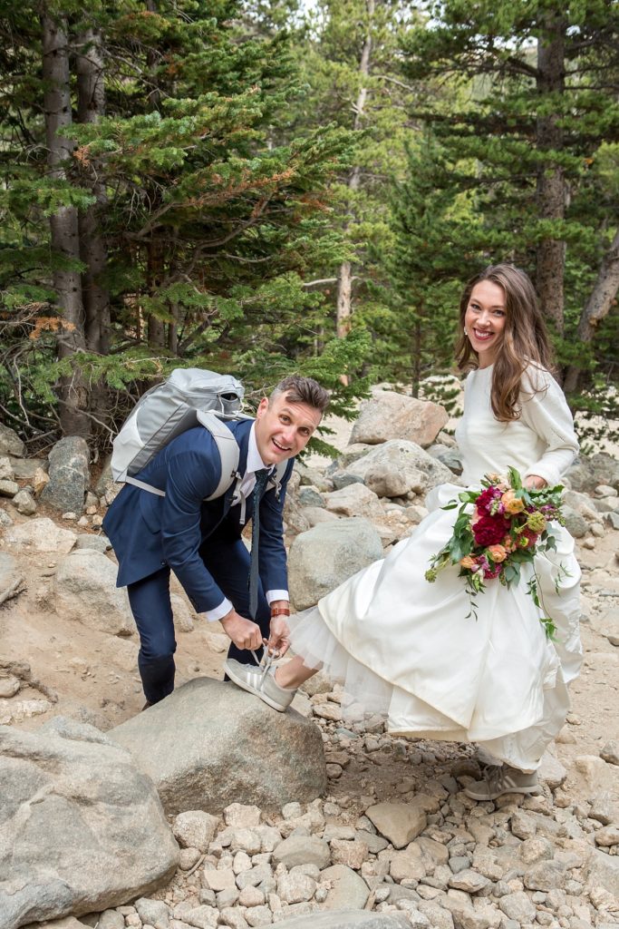 bride and groom hiking to St Mary's Glacier