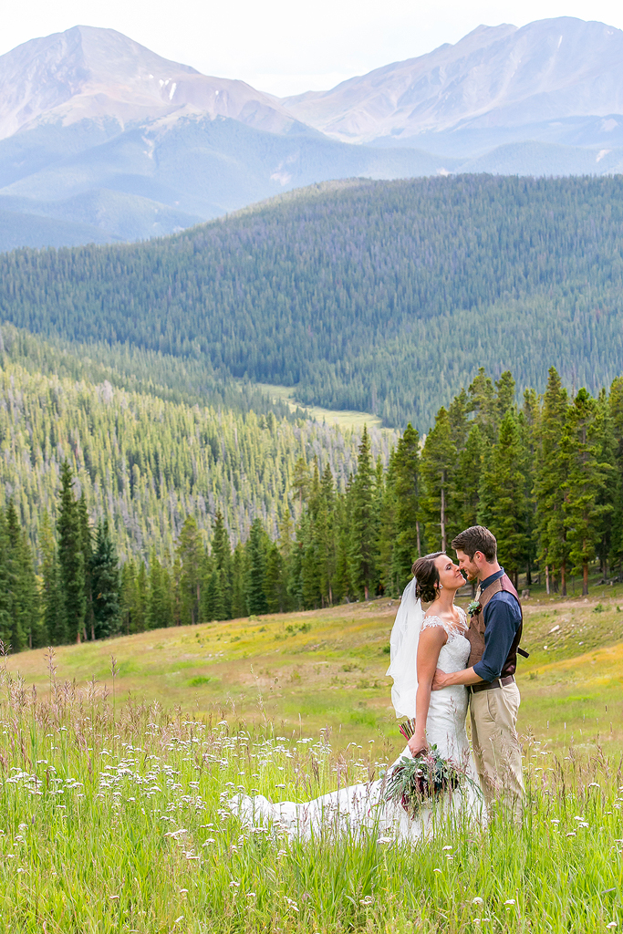Kendra and Levi embrace in a sea of wildflowers on top of Keystone Mountain during their Colorado wedding.