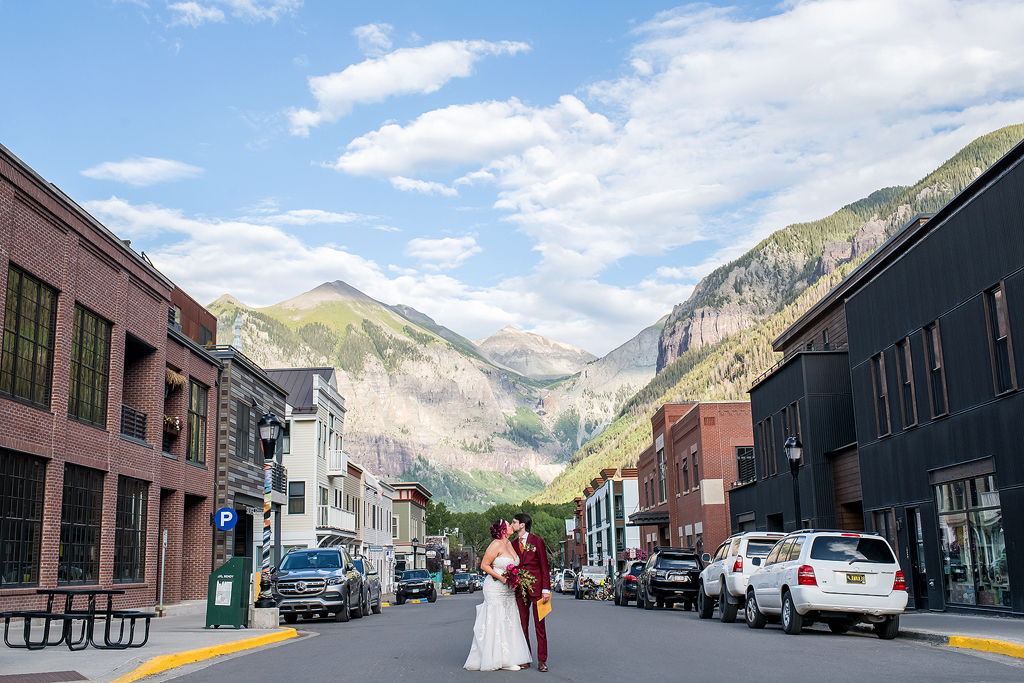 Devin and Savannah kissing in downtown Telluride during their mountain wedding.