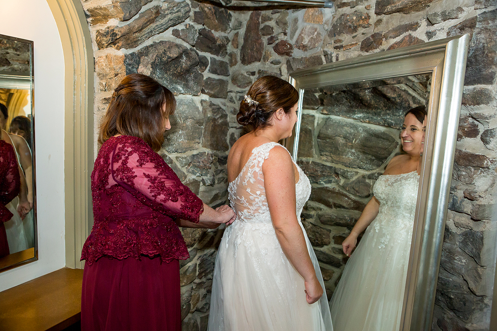 Bride gets ready in front of a large mirror at Chief Hosa Lodge.