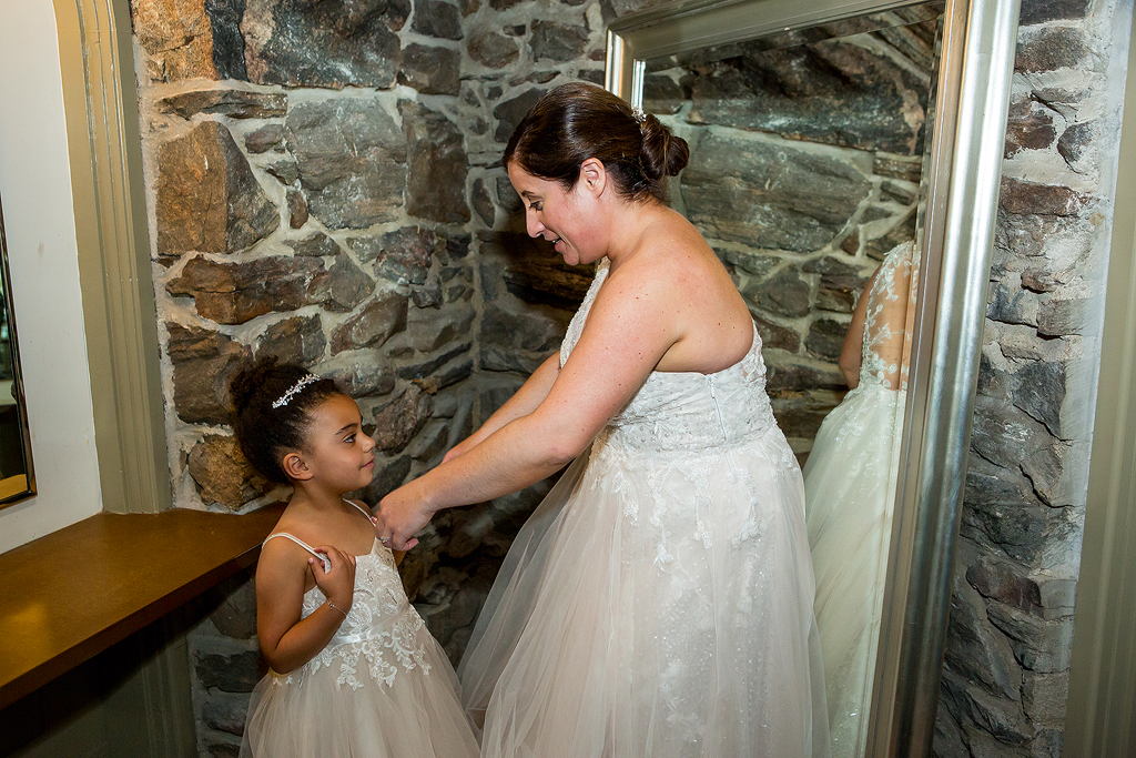 Bride and young daughter get ready before their wedding.