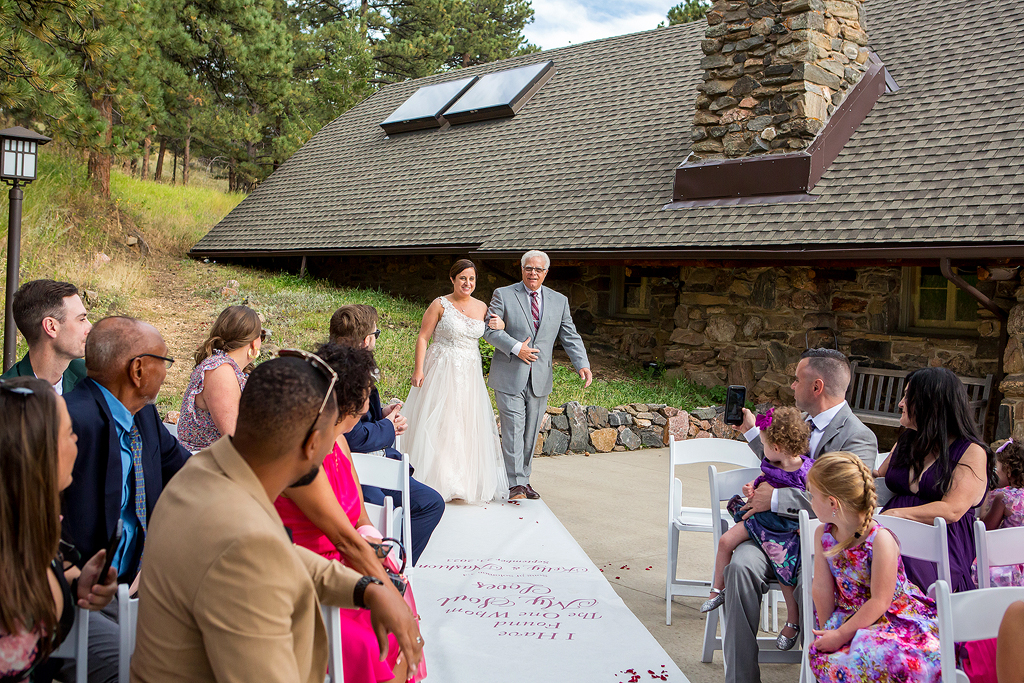 Bride walks down the aisle with her dad.