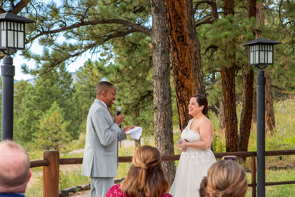 Bride and groom laugh during this mountain wedding ceremony in Colorado.