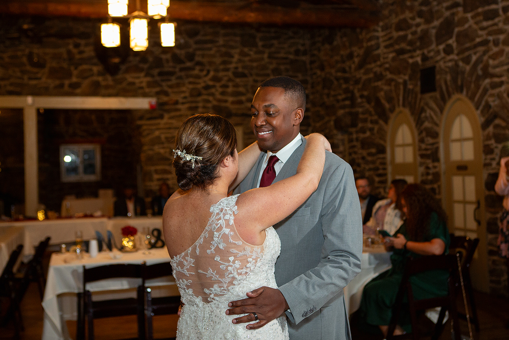 Groom smiles during first dance at Chief Hosa Lodge near Evergreen, Colorado.