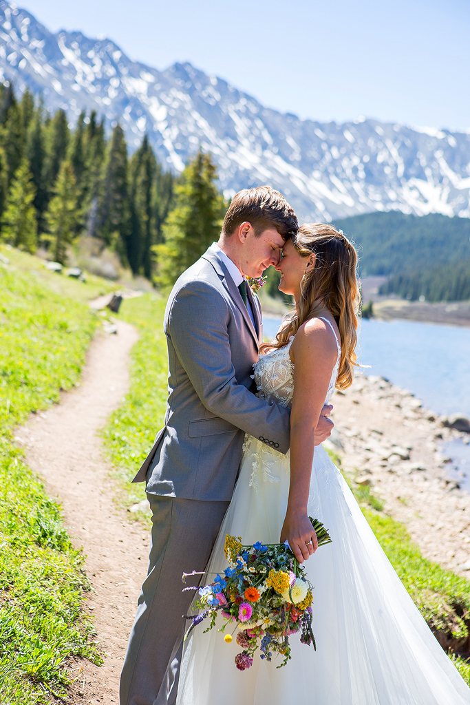 Madi and Chase embrace along a trail at Clinton Gulch Dam Reservoir during their mountain elopement