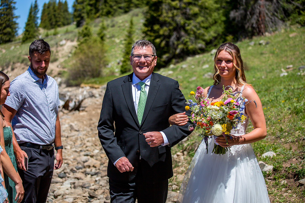 Madi walks with her dad before the elopement ceremony