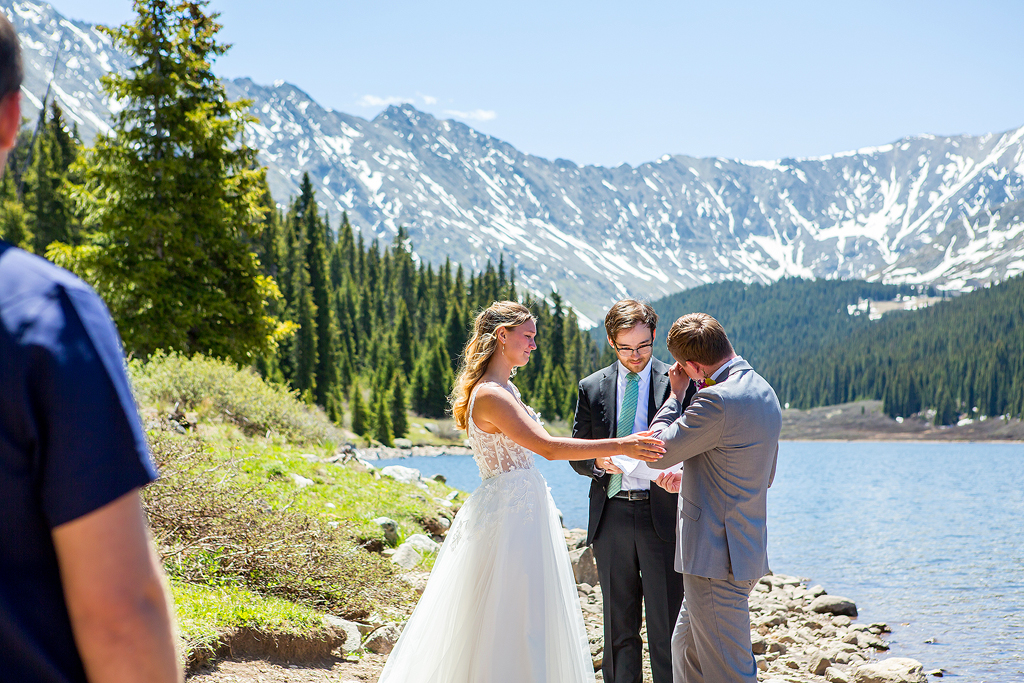 groom cries during a mountain elopement ceremony at an alpine lake in Colorado.