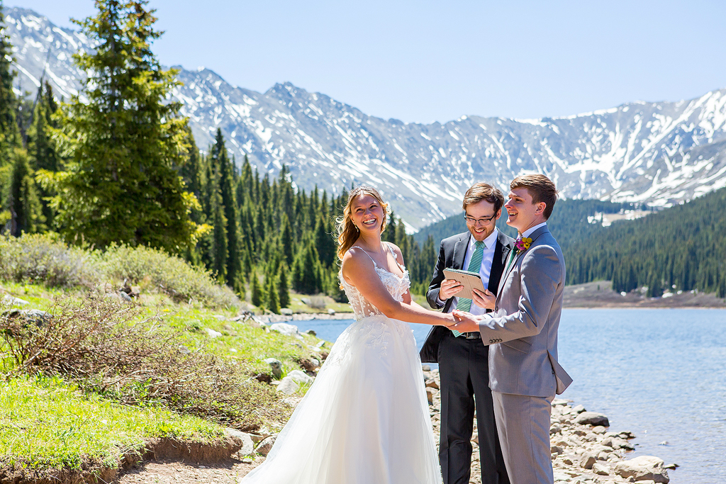 Madi and Chase laugh during their elopement vows in Colorado.