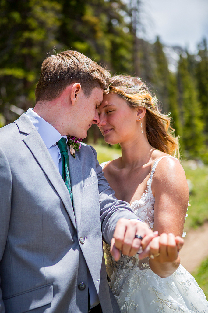 Madi and Chase snuggle showing their wedding rings.