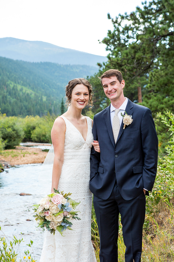 Erin and Chip smile in front of a creek in Rocky Mountain National Park, Colorado.