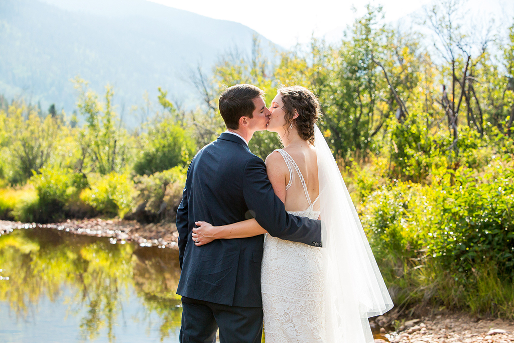 Bride and groom kiss in the mountains near Estes Park, CO.