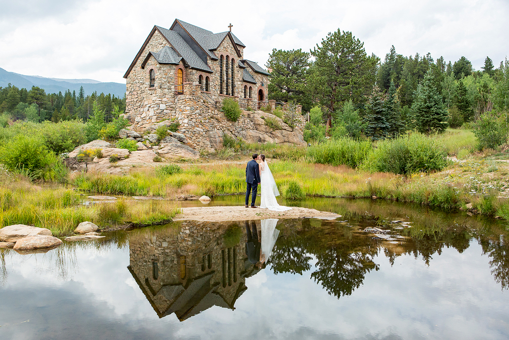 Bride and Groom kiss in front of Chapel on the Rock in Allenspark, CO
