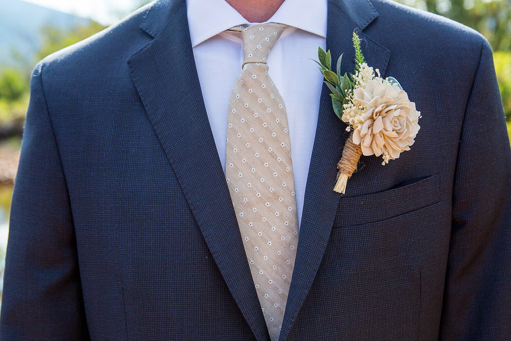 Close up of groom's tie, jacket and boutonniere