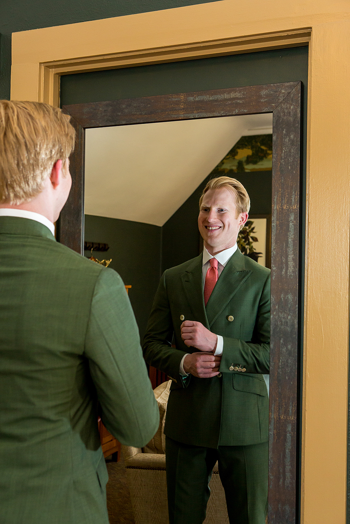 Jacob adjusts his cufflinks in the mirror at Boettcher Mansion.
