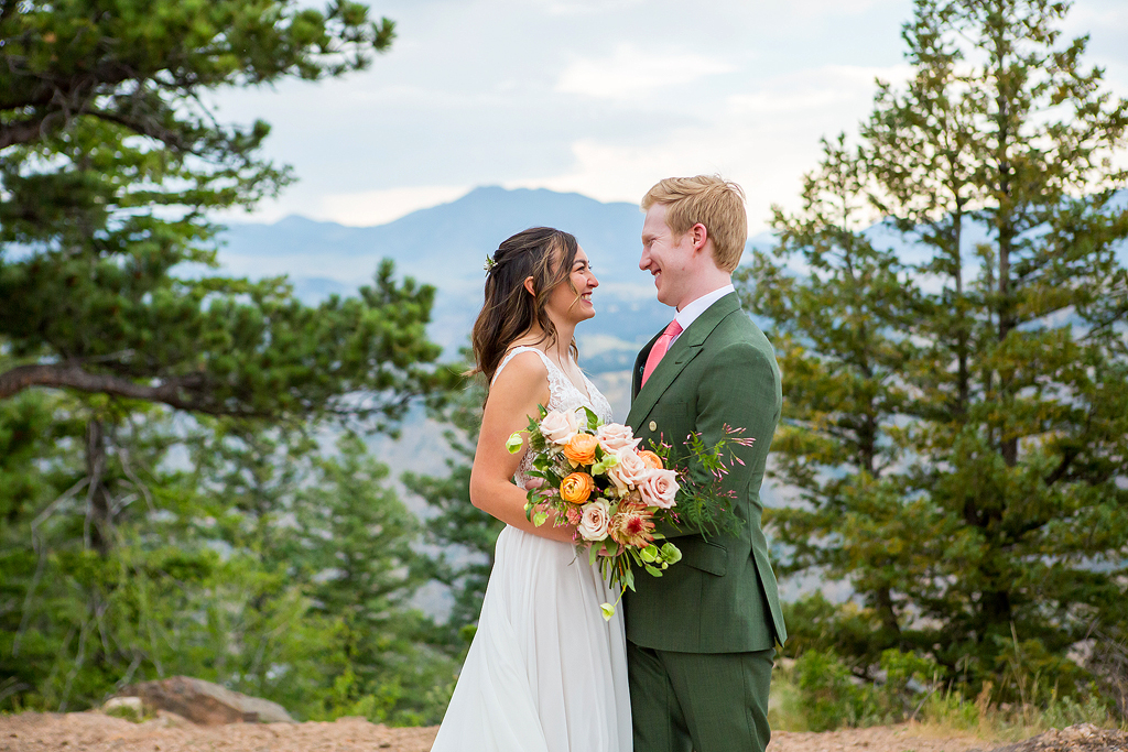 Jacob and Christine embrace during their Boettcher Mansion wedding with the mountains behind them.