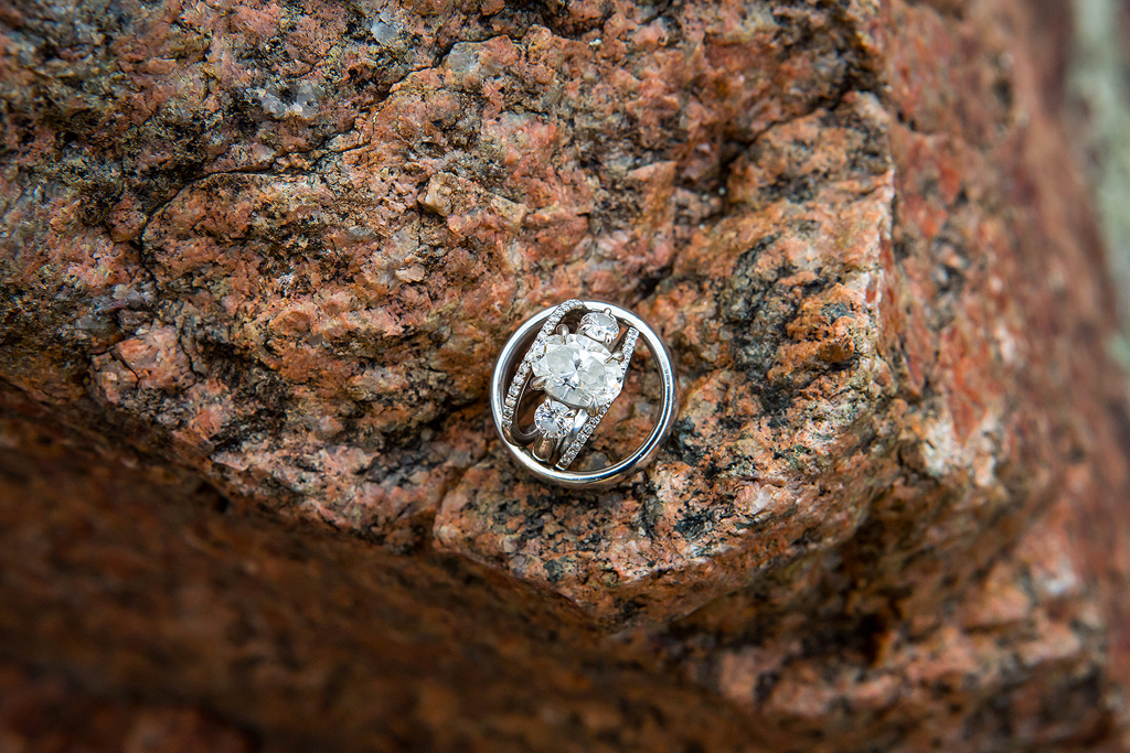 Closeup of wedding rings on a granite rock.