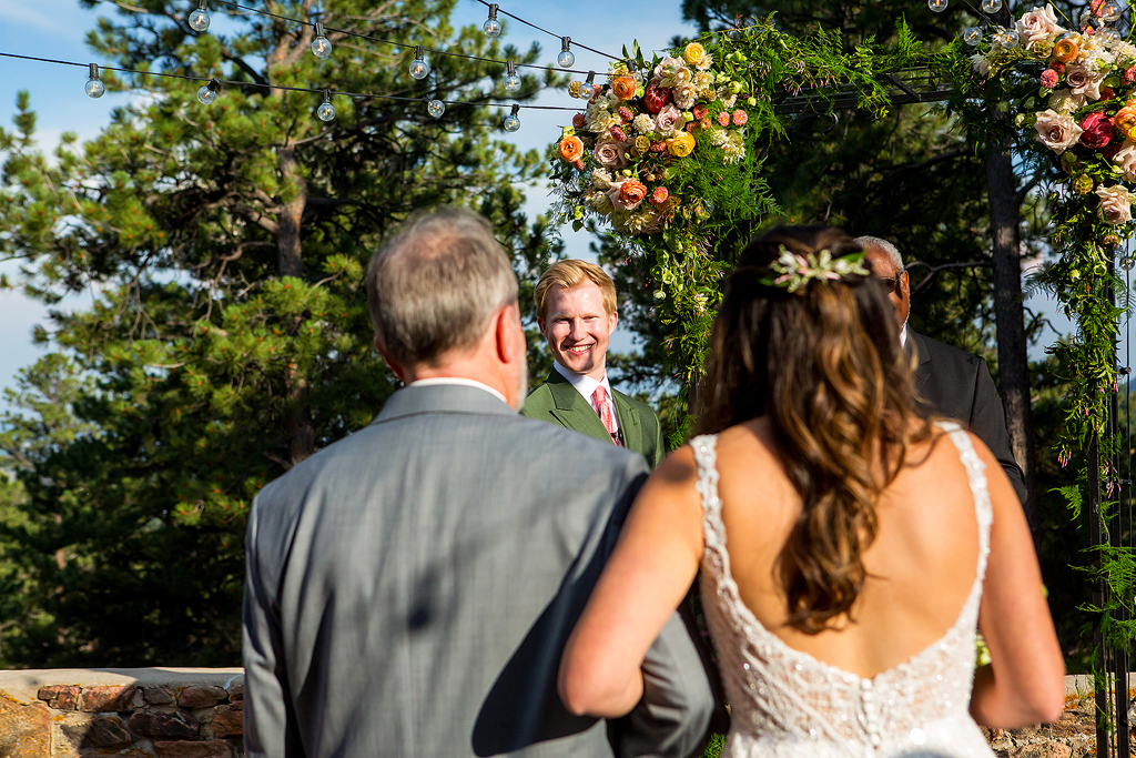 Jacob face with Christine and her dad in the foreground as they start their wedding ceremony