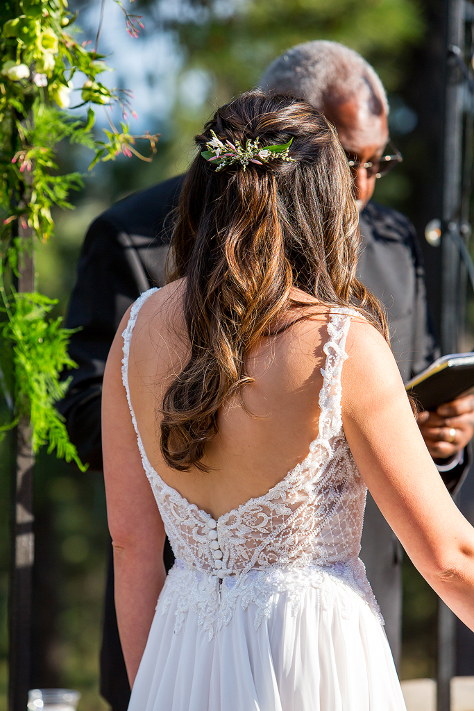 The back of Christine's wedding dress during the ceremony showing off her lace and hair.