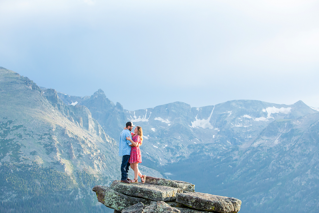 Couple hugs in front of a panoramic mountain view along Trail Ridge Road in RMNP, Colorado.