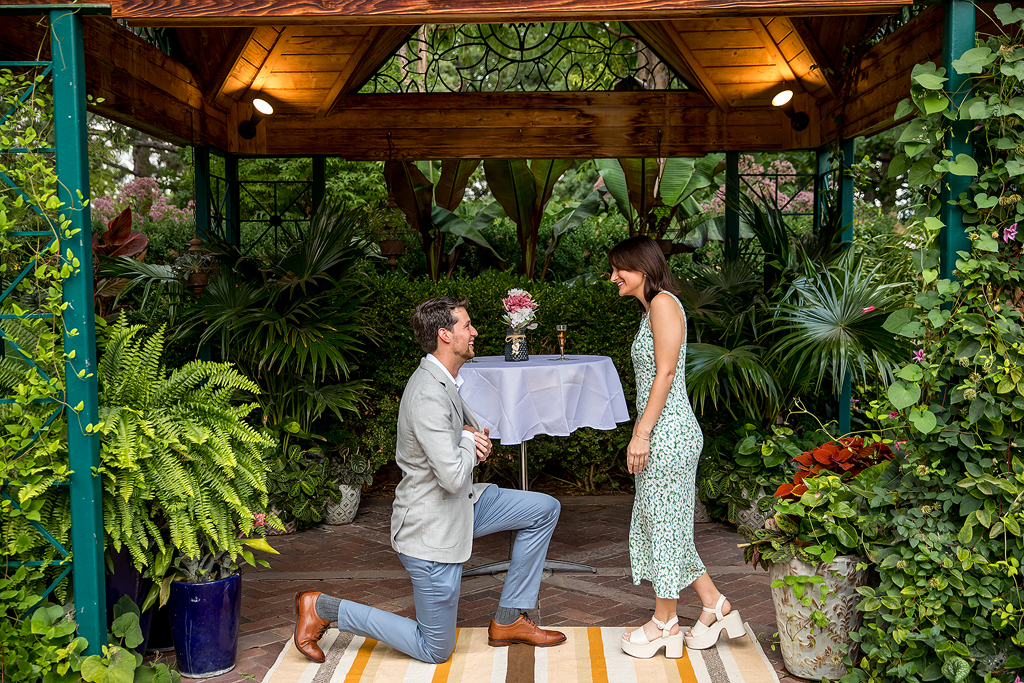 Conor kneels to propose to Sisana at the Denver Botanic Gardens