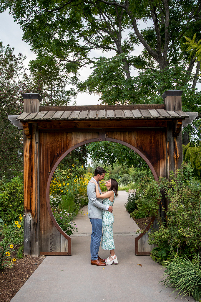 Conor and Sisana cuddle surrounded by urban gardens in Denver.