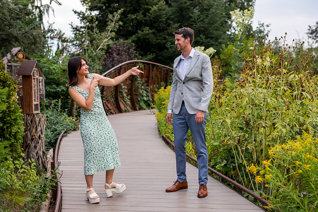 Conor and Sisana walk playfully along a wooden boardwalk at Denver Botanic Gardens.