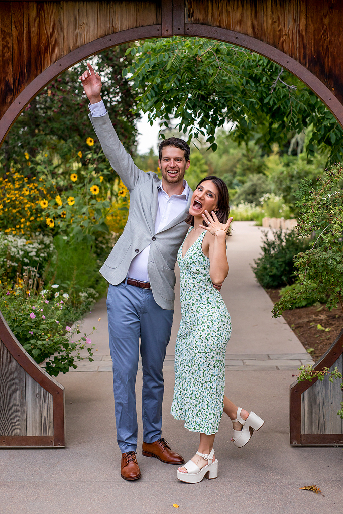 Couple cheers and shows off engagement ring in Denver, Colorado.