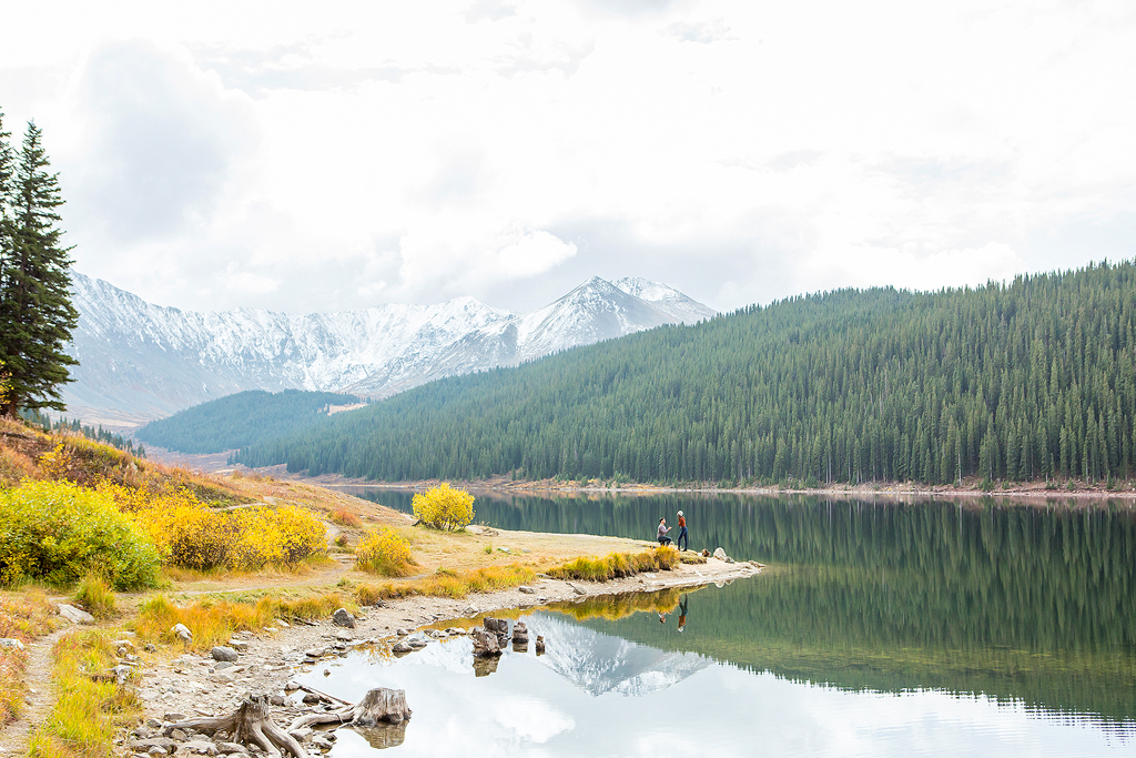 Colorado engagement with Dijon and Mana as Dijon kneels in front of an alpine lake to propose.