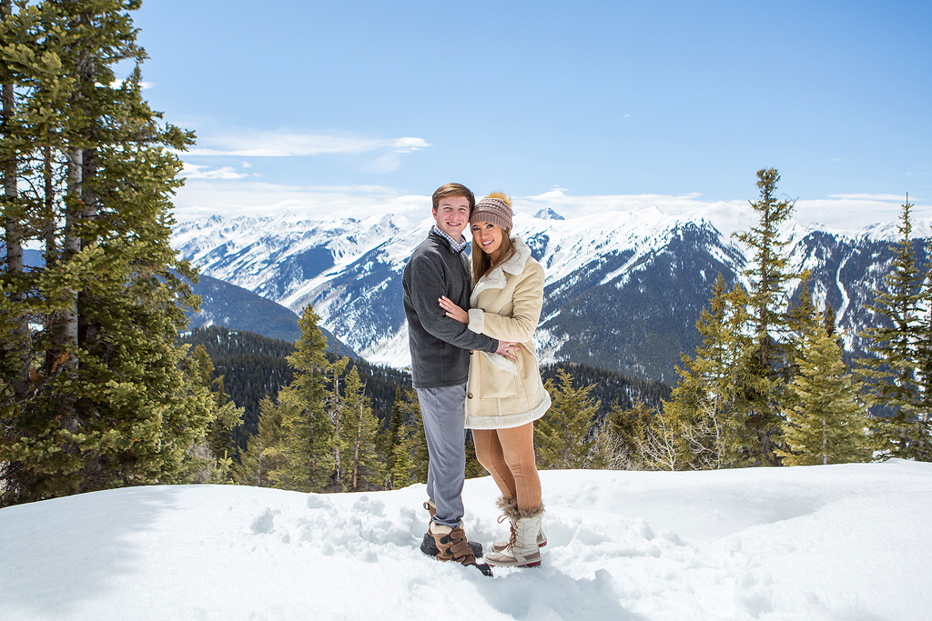 Snow capped peaks show behind Weston and Kate as they hug in Aspen, Colorado.