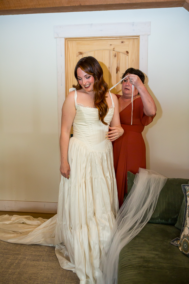 Bride puts on her dress during this Colorado elopement.