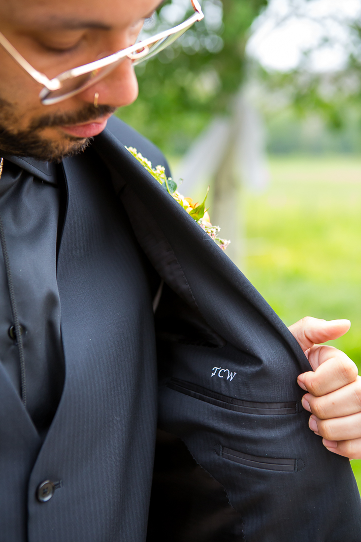 Groom shows the inside of his suit with custom embroidery in Colorado.