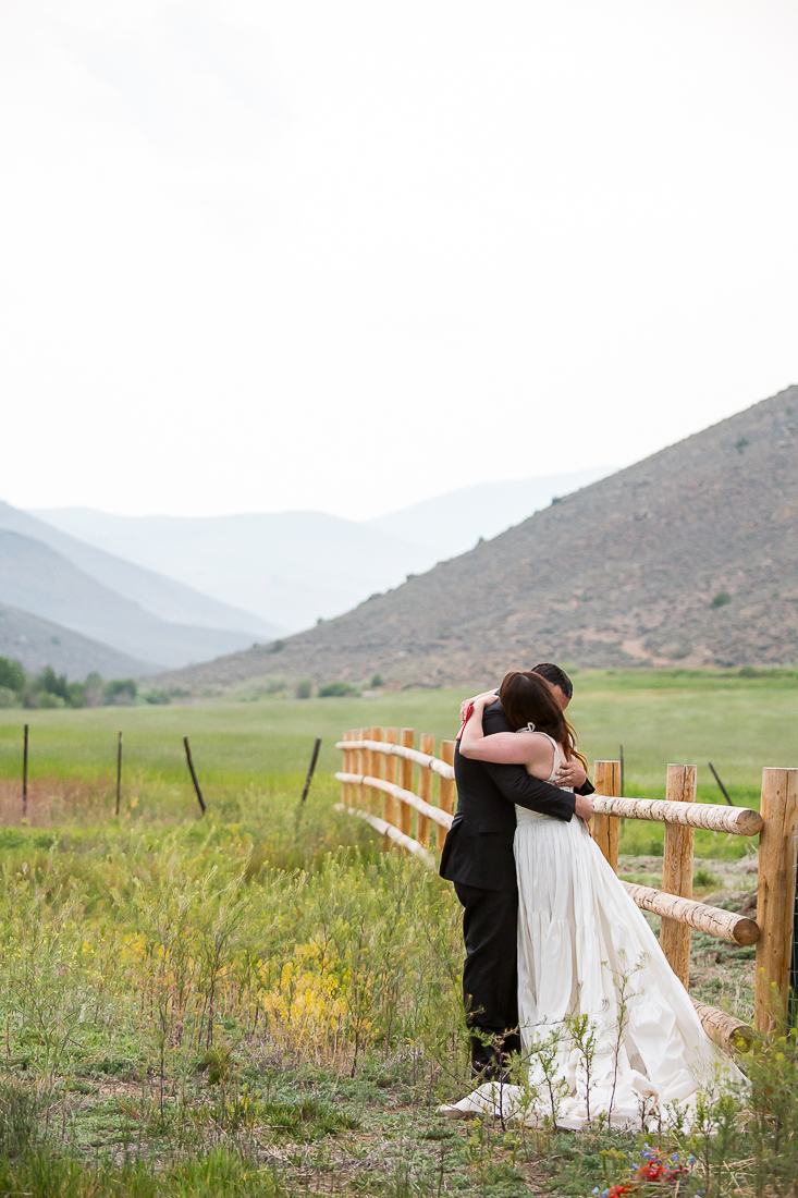 Bride and groom hug on a ranch after private vows.