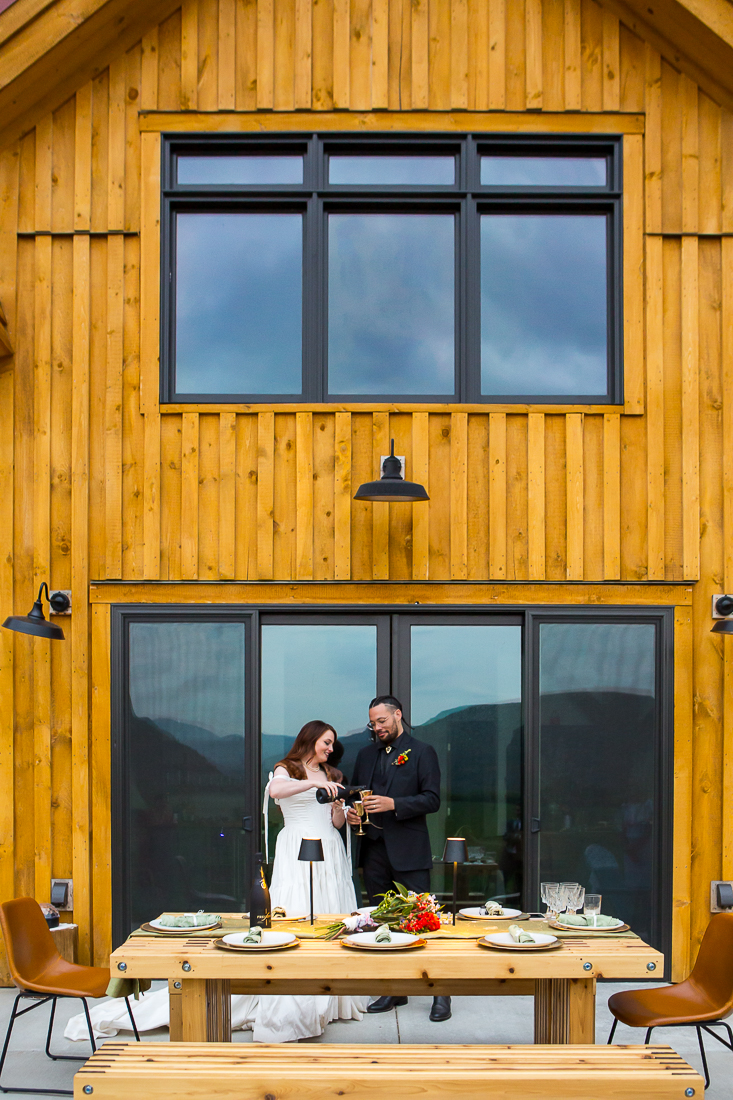 Bride and groom pour champagne during their elopement.