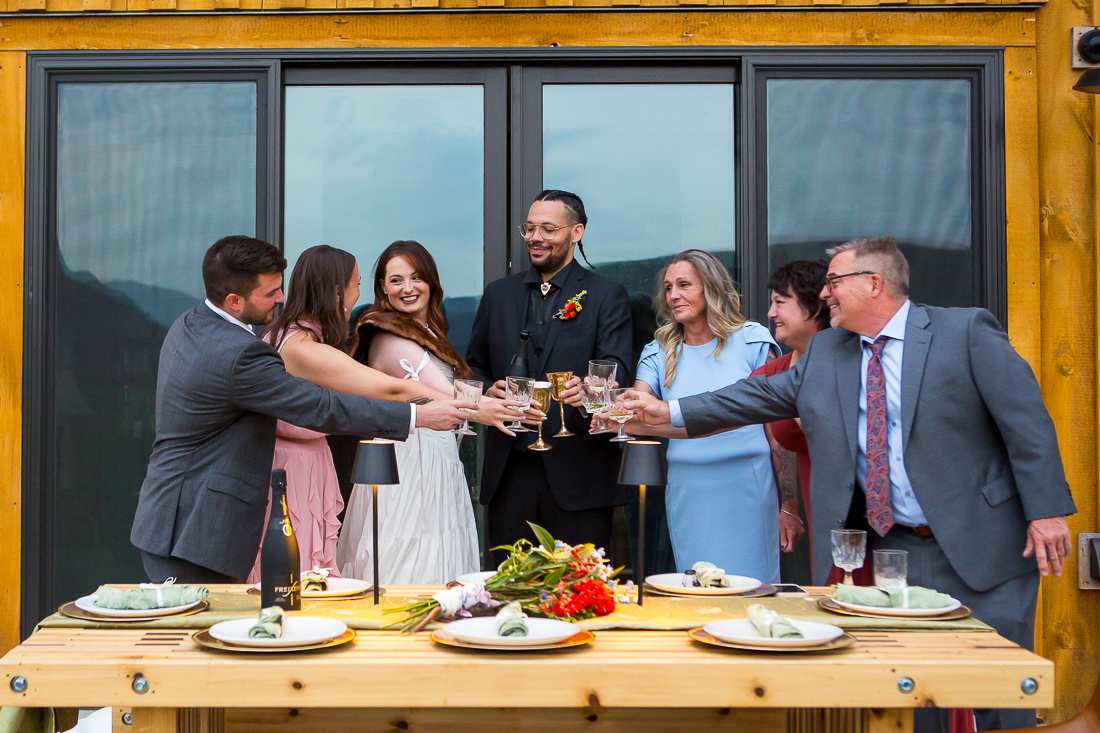 Bride and groom toast with their family after elopement at an airbnb
