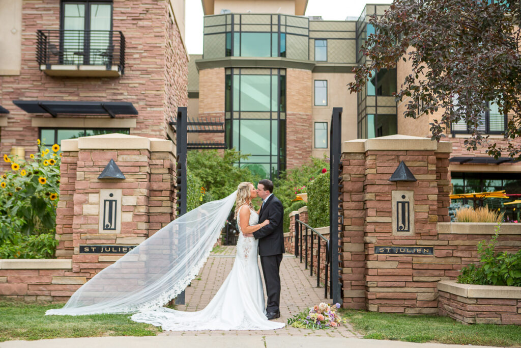 Bride and groom kiss in front of the St Julien Hotel, a wedding venue in Boulder Colorado.